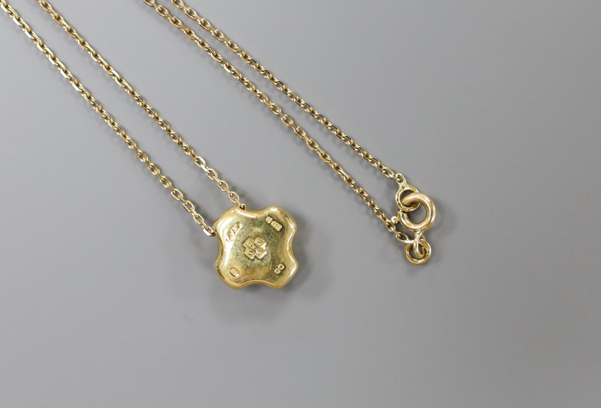 A modern 18ct gold and single stone diamond set quatrefoil pendant, 7mm, on an 18ct gold fine link chain, 38cm, gross weight 6 grams